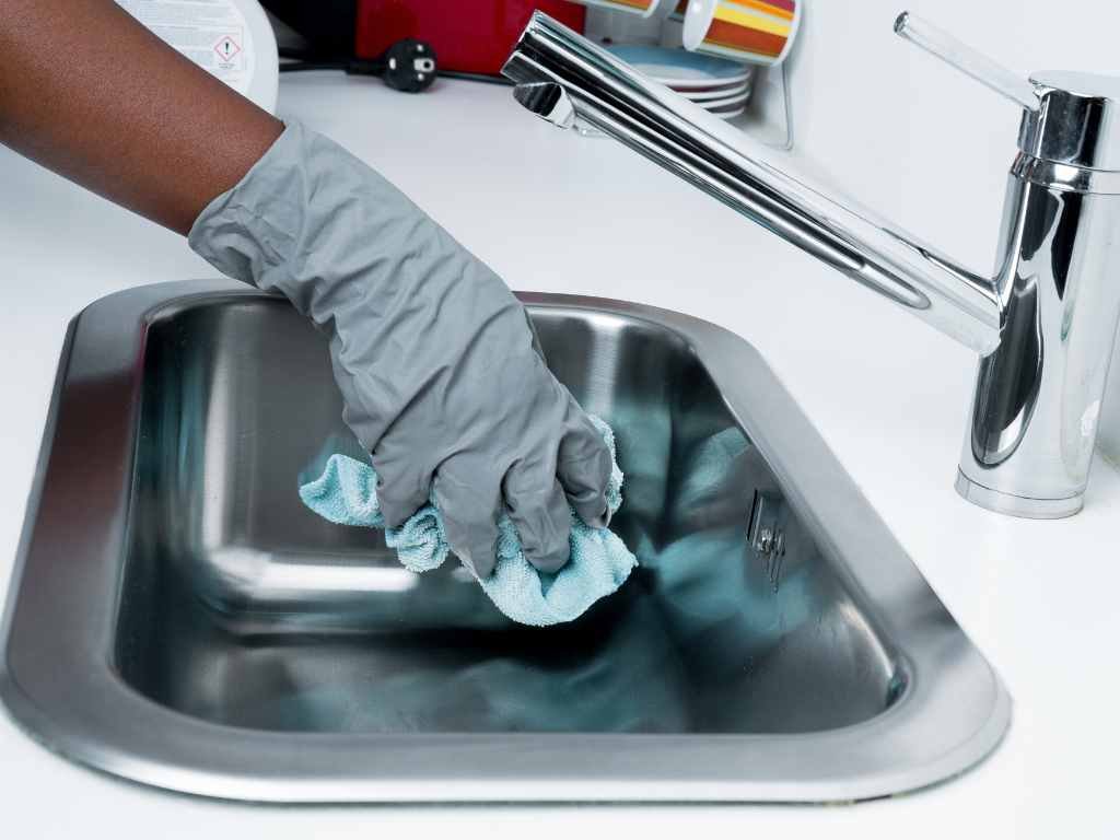 black individual cleaning the sink