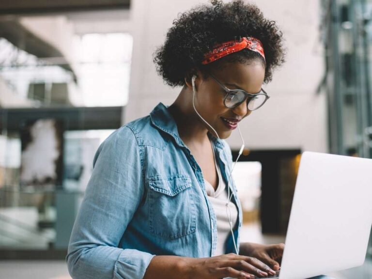 black female student studying while wearing headphones