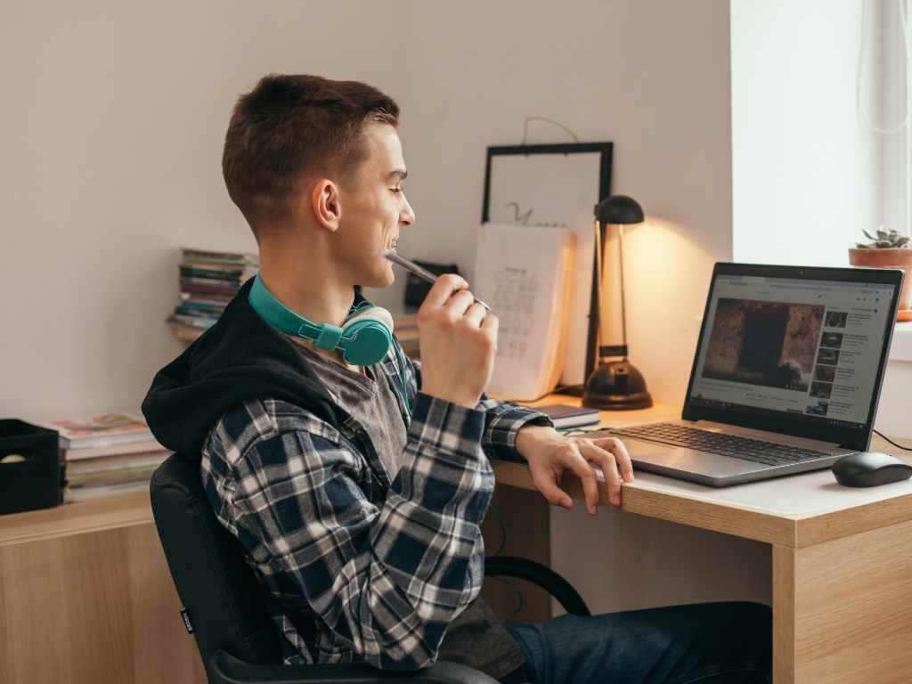 college boy inside his college dorm room watching youtube