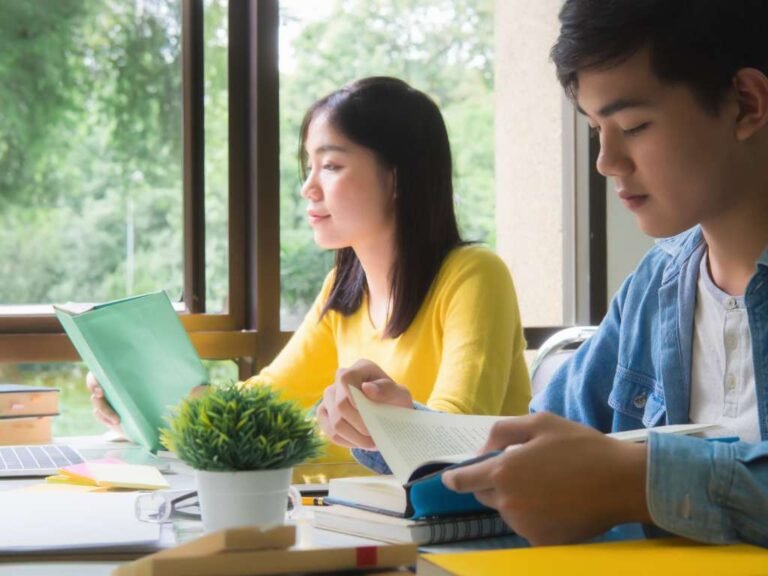 two asian college students studying together