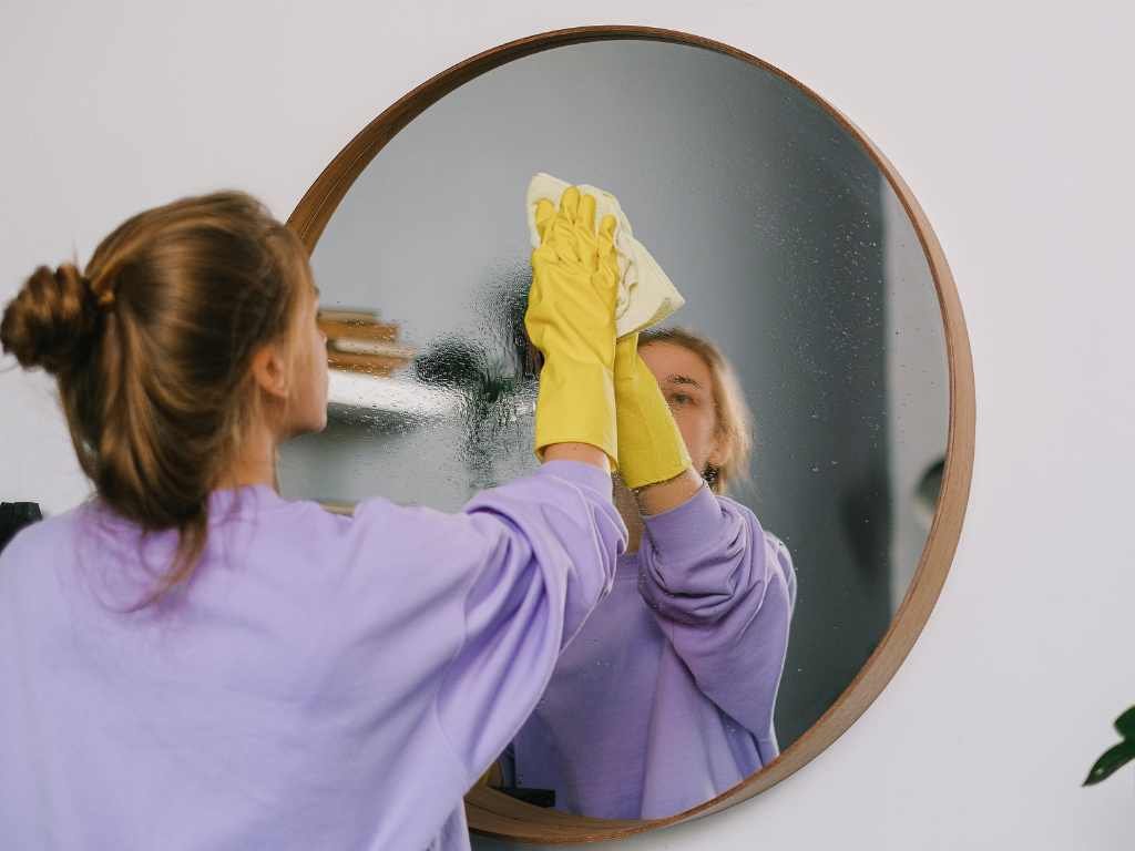 girl cleaning the mirror