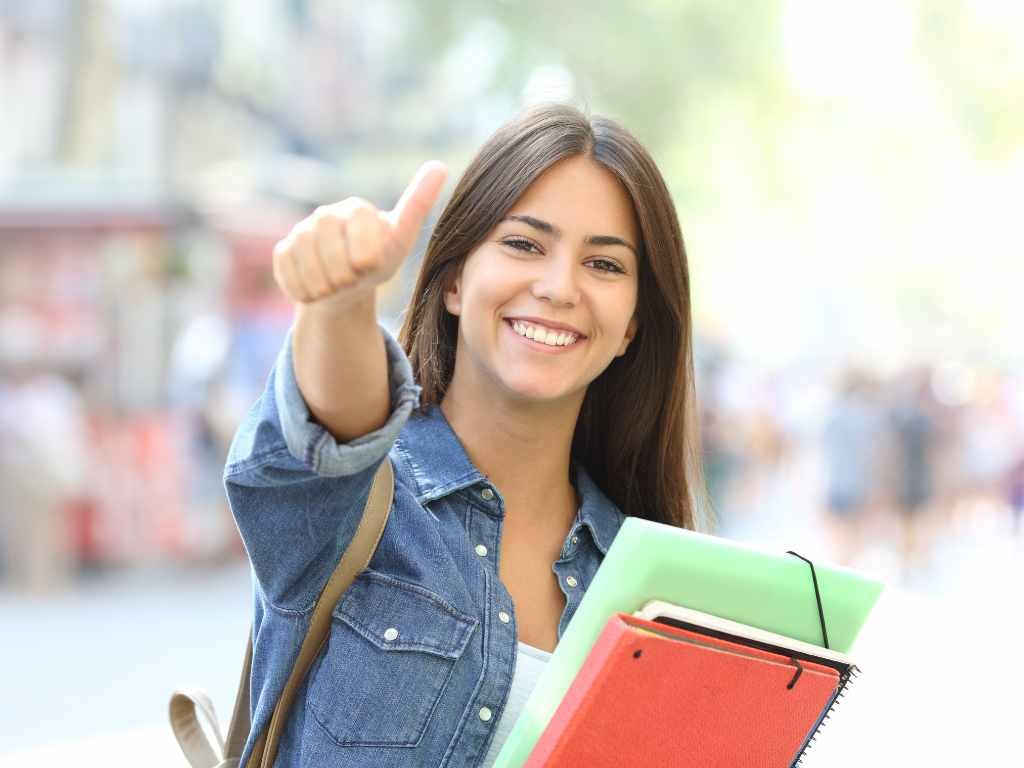 happy female student smiling with a thumbs up