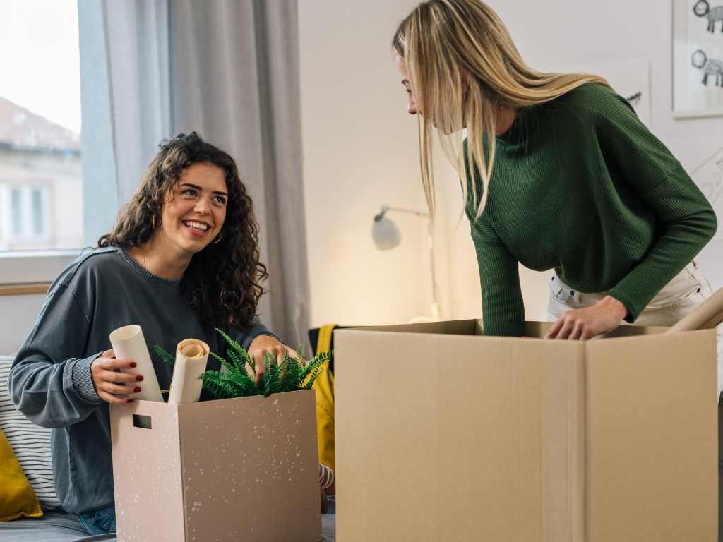 two girls unpacking in a college dorm room