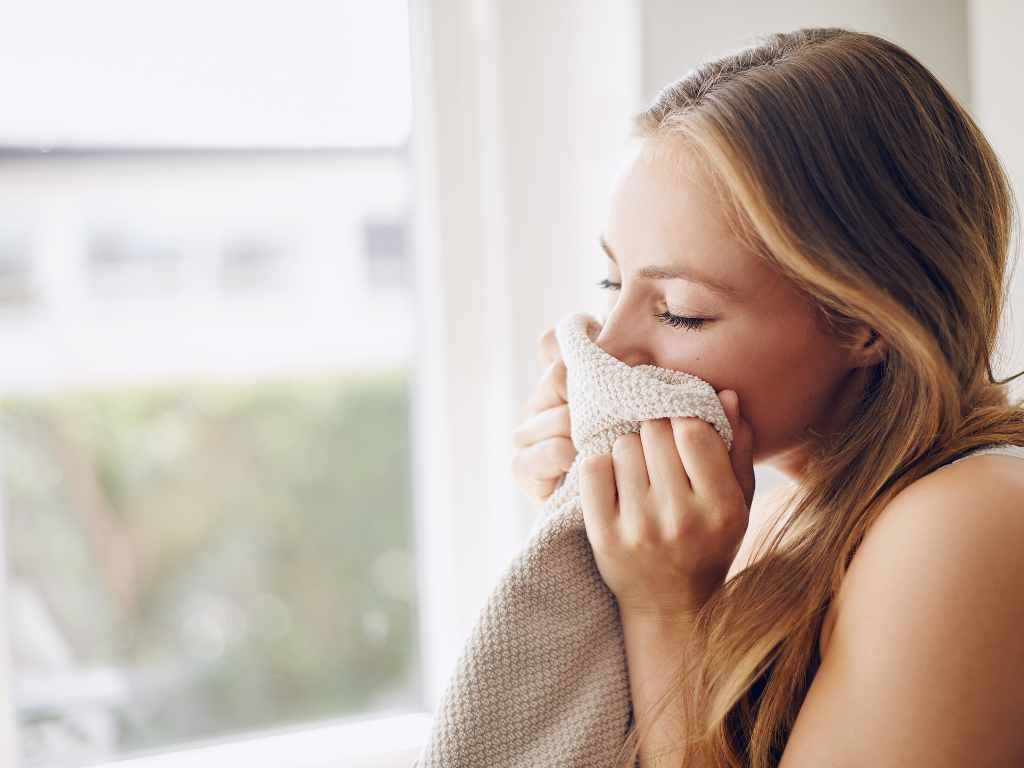 woman smelling her blanket