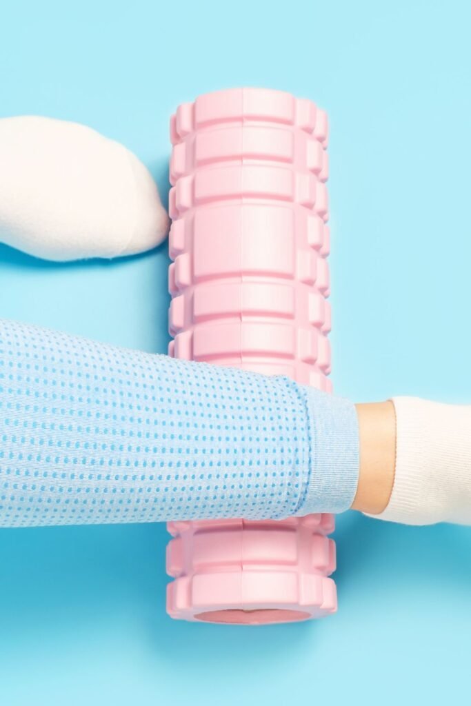 pink foam roller with a woman rolling it under her leg