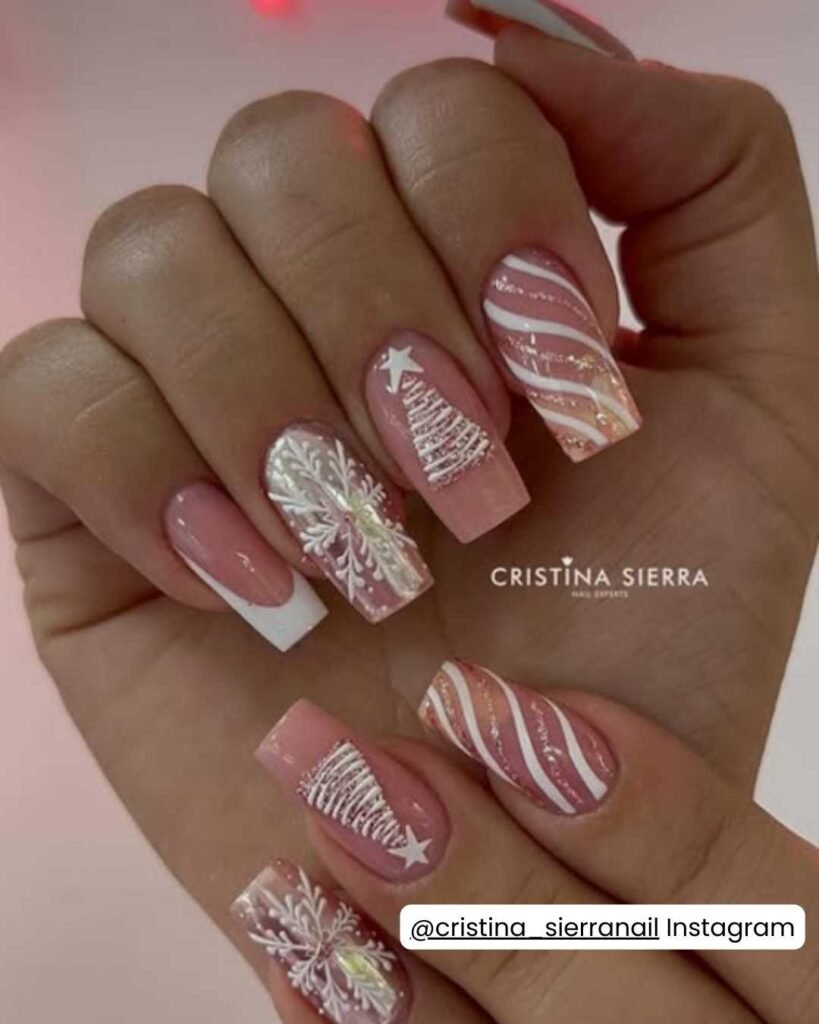 Soft pink nails with white snowflakes, candy cane stripes, Christmas trees, and subtle glitter accents.