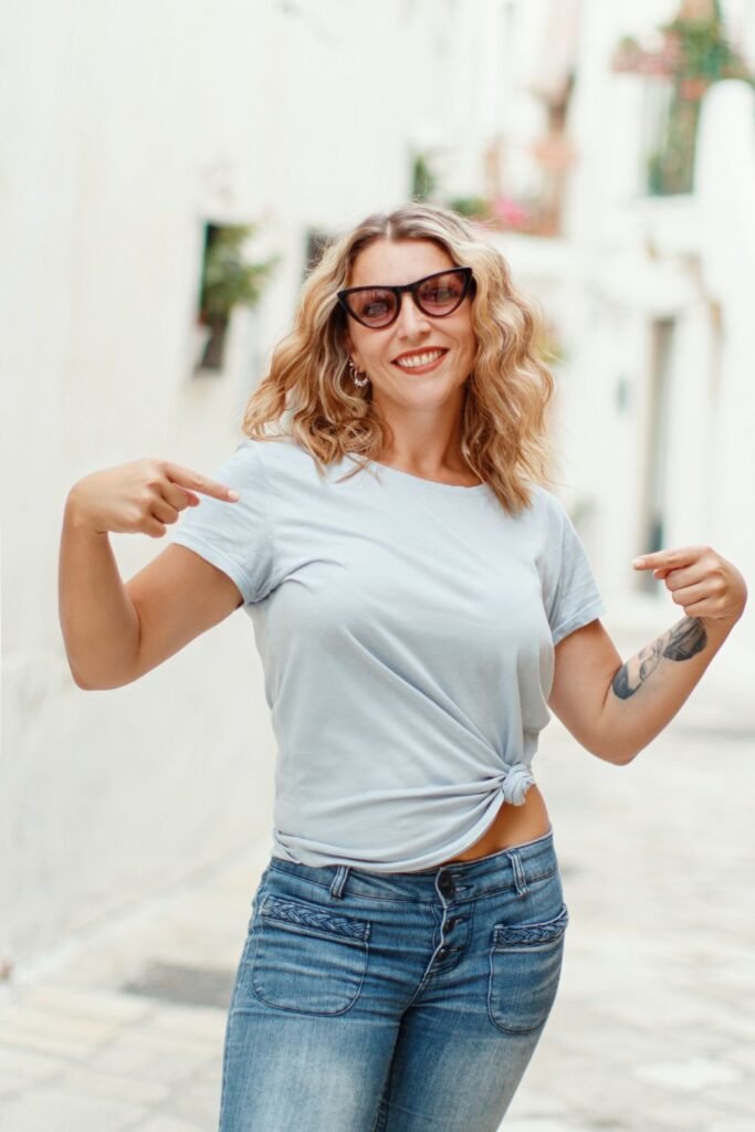 young blonde woman wearing a lose white t-shirt knotted at the front