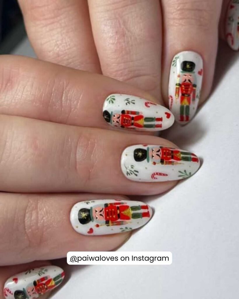 Hand-painted Nutcracker-themed nails with soldiers, candy canes, and mistletoe on a crisp white base.