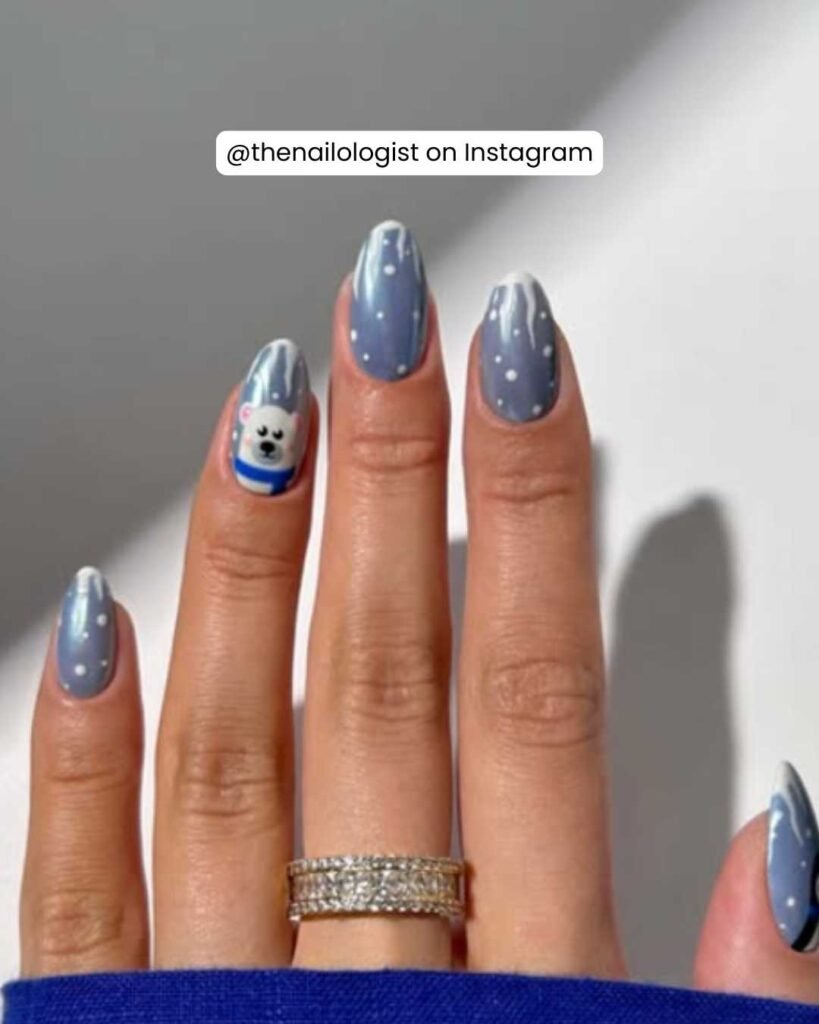 Frosty blue nails with a polar bear design, snowflakes, and gradient effects for a winter vibe.