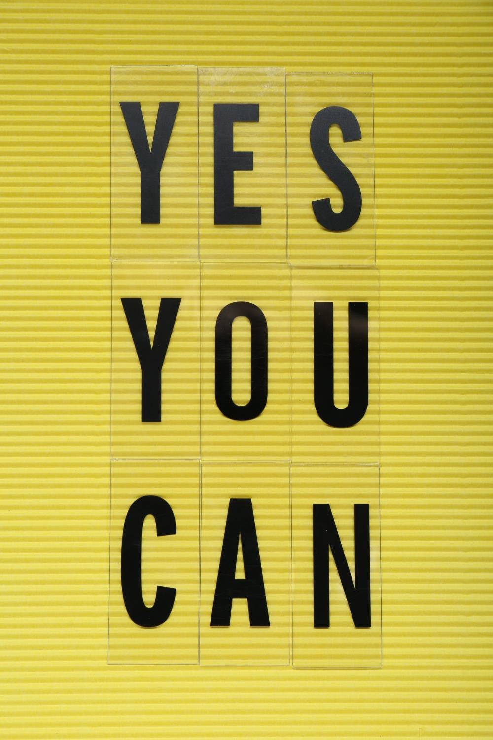 The phrase 'Yes You Can' written on a yellow background.