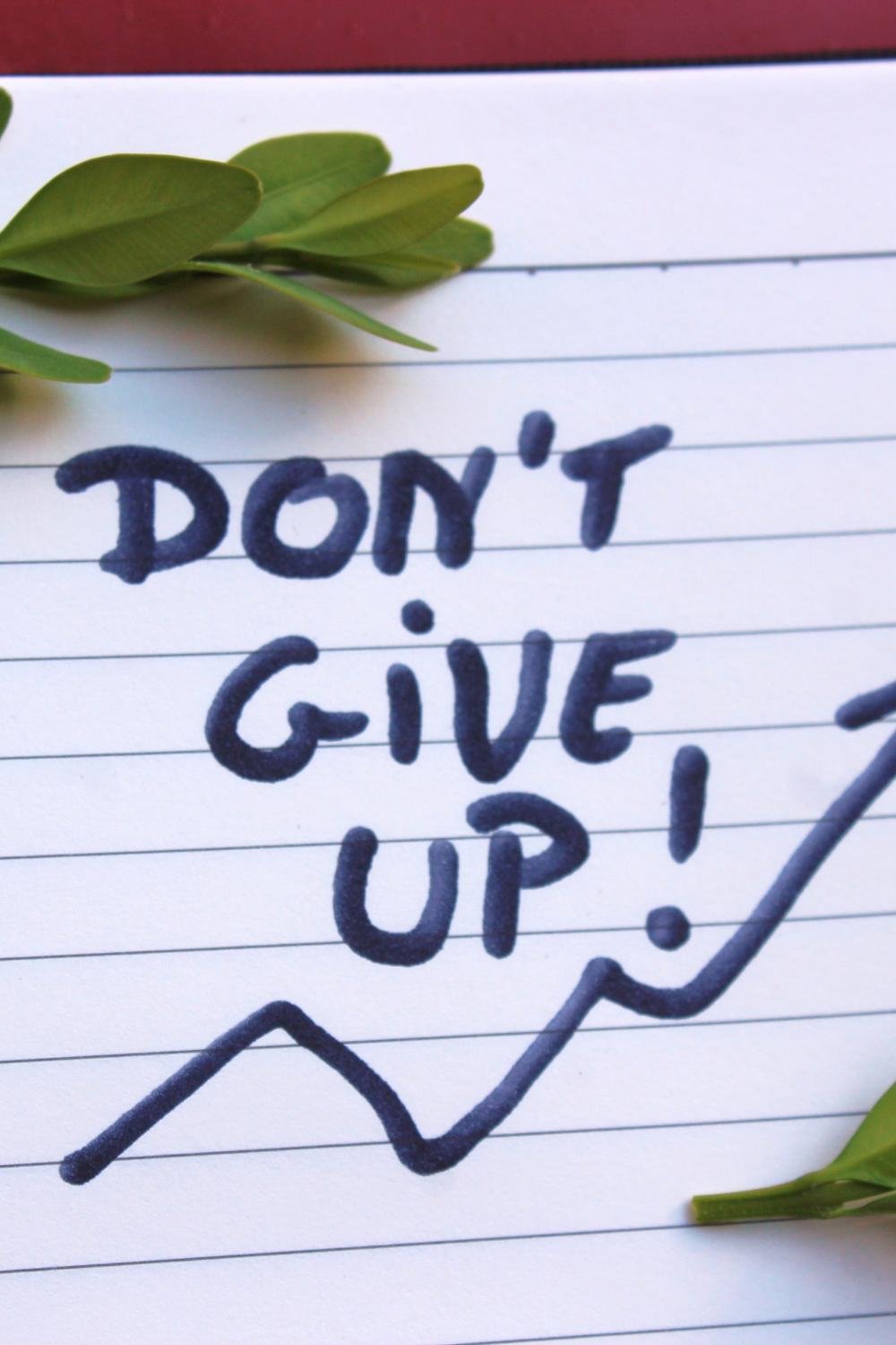 ''Don't give up'' phrase written on a paper