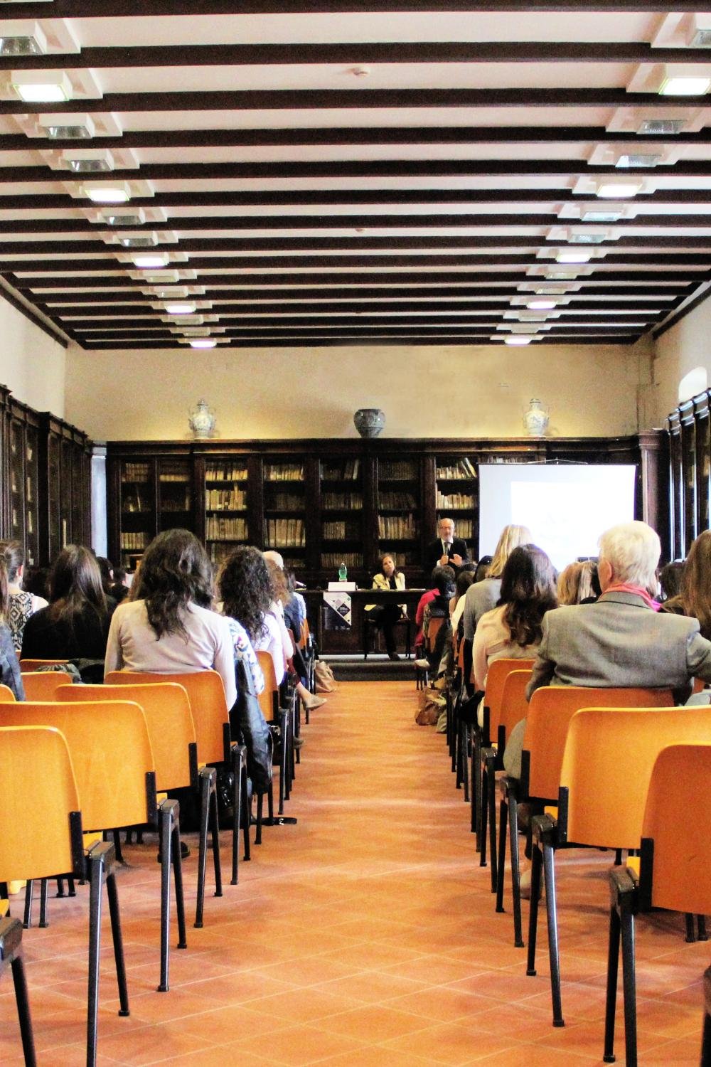 A classroom filled with students, with a professor standing at the front.