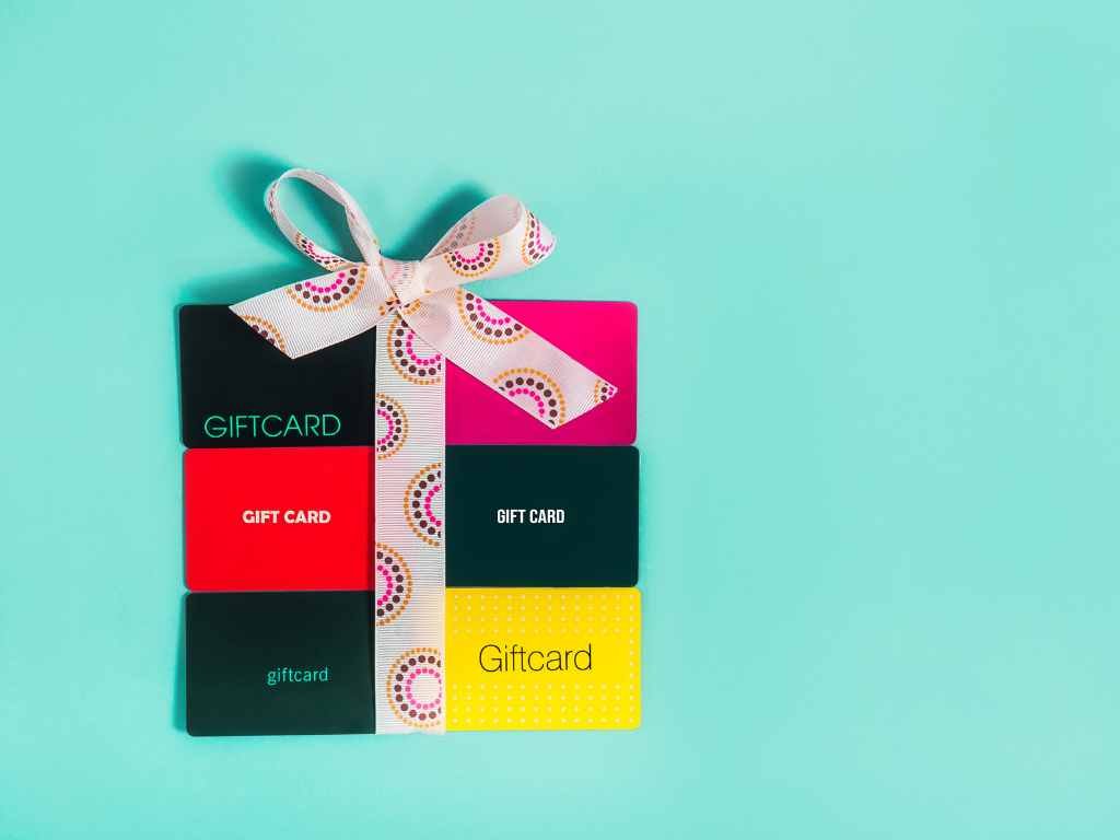 gift cards on a turquoise table with a bow