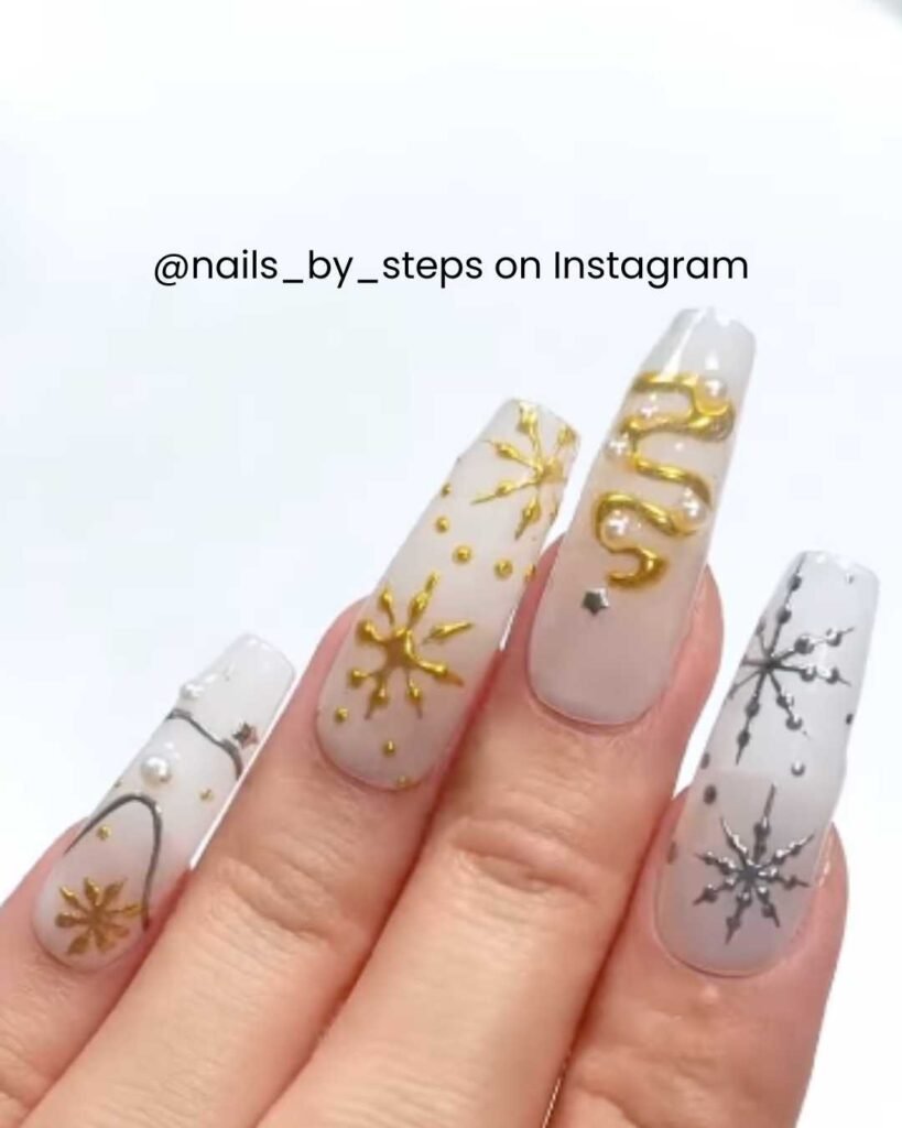 Neutral nails with gold and silver snowflakes, starry designs, pearls, and metallic details for a winter wonderland vibe.