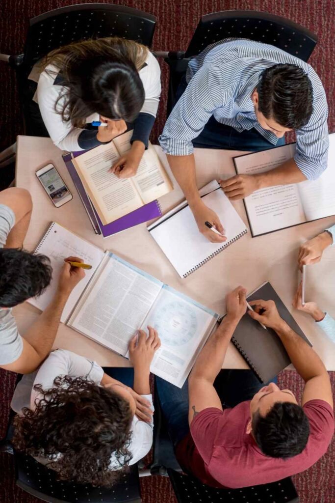 view above of college students studying together in the library 