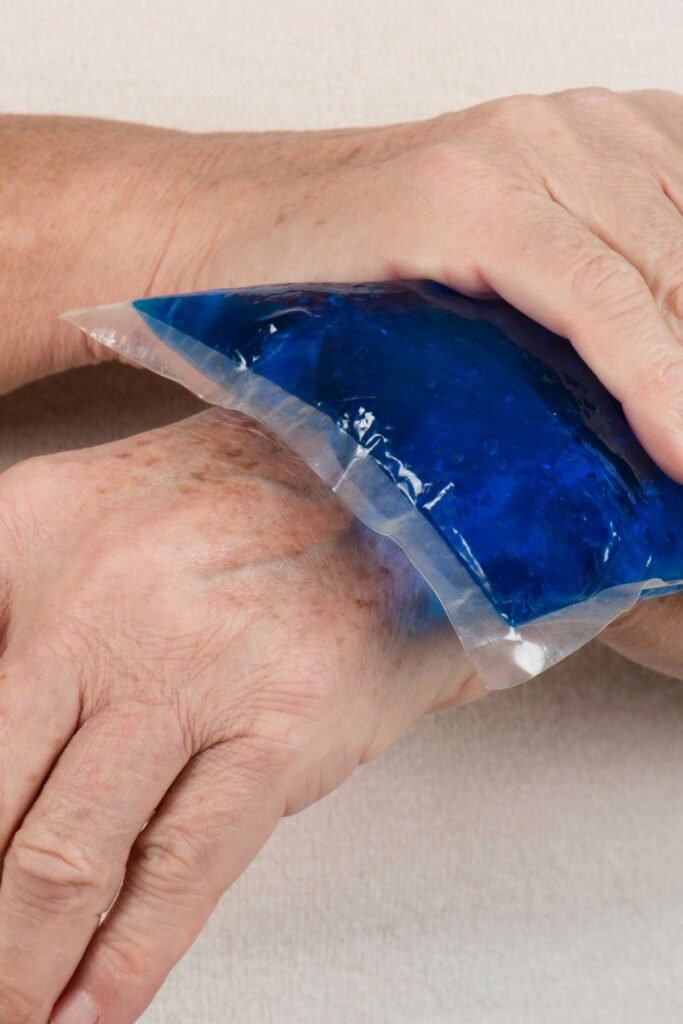 a man applying a blue ice or heat pack on his hand