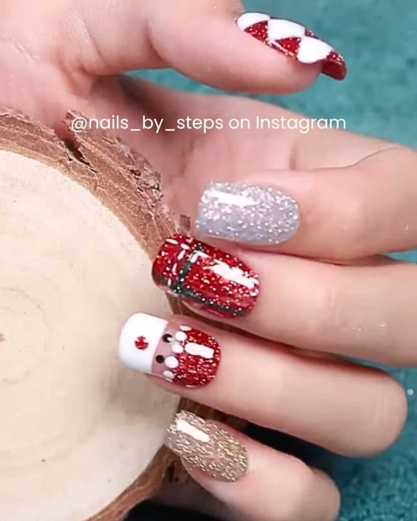 Red and gold glitter nails with a Santa design, silver shimmer, and present-wrapped patterns.