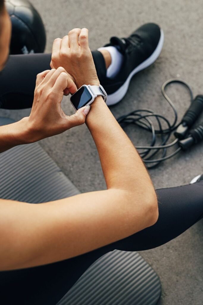 young woman resting at the gym looking at her fitness tracker watch