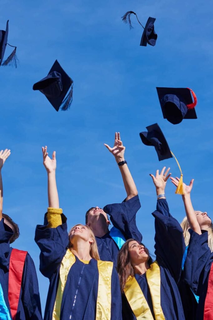 students graduation throwing their hats in the air