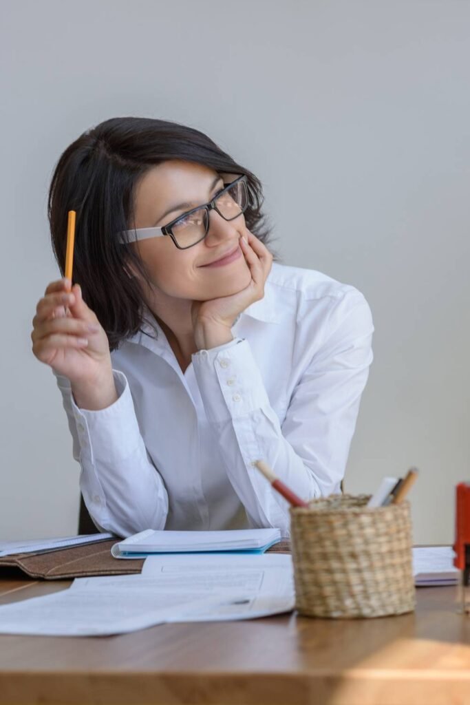 Young female student wearing glasses smiling with a pencil in her hand